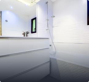 salle de bain lumineuse avec baignoire et double lavabo et mirroir